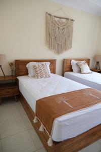 two beds sitting next to each other in a bedroom at Kala Surf Camp in Uluwatu