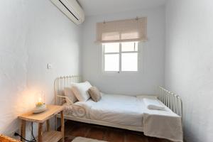 a small bedroom with a bed and a window at La Cueva in Mijas