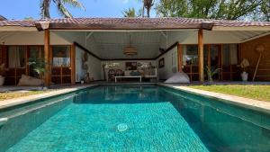 a swimming pool in front of a house at villa Oceane in Gili Air