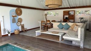 a living room with a couch and a pool at villa Oceane in Gili Air