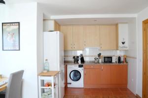 a kitchen with a washing machine and a microwave at Dúplex El refugio de Porma in Puebla de Lillo