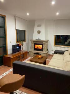 a living room with a couch and a fireplace at Preciosa casa en Bembrive in Vigo