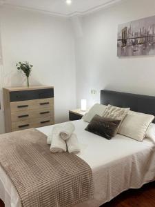 a bedroom with a bed with pillows and a dresser at Preciosa casa en Bembrive in Vigo