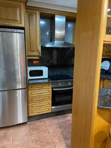 a kitchen with a stainless steel refrigerator and a stove at Preciosa casa en Bembrive in Vigo