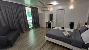 マシバリーにあるSIS Tourist Villa, Mathiveri, Maldivesのベッドルーム1室(ベッド1台、ソファ付)
