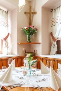 Gasthof Sauer GmbH في Straß in Steiermark: غرفة طعام مع طاولة مع صليب على الحائط