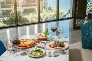 a table with plates of food and glasses of wine at Mandala Cham Bay Mui Ne in Phan Thiet