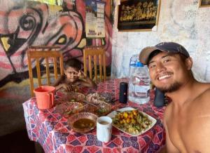 a man sitting at a table with a plate of food at Sandaru Surffing Inn in Weligama