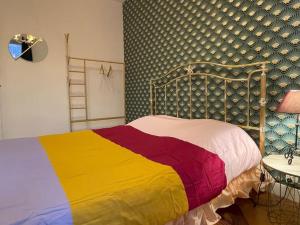 a bedroom with a bed with a colorful blanket at Maison de charme 95m2, 4 chambres in Saint-Denis