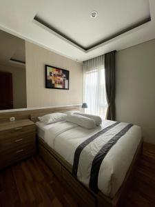 um quarto com uma cama grande e uma janela em Valle Verde Villas em Bandung