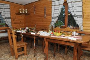 ein Esszimmer mit einem Holztisch und Stühlen in der Unterkunft Sadyba Magnat Hotel in Dilyatyn
