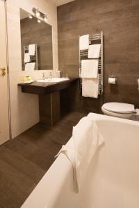 a bathroom with a tub and a sink and a toilet at West Cork Hotel in Skibbereen