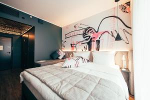 a bedroom with a bed with a wall with graffiti at Hotel AX in Helsinki