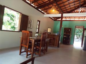 a dining room with a wooden table and chairs at Casa Malibu in Ilha de Boipeba