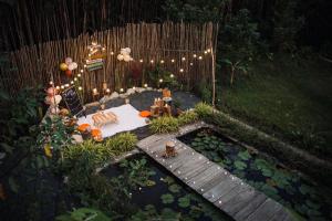 patio trasero con jardín y terraza de madera en Bungalow - Farmstay Hoa Rừng U Minh en Cà Mau