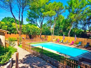 a swimming pool with chairs and a fence around it at L'Entre Nous, piscine et jacuzzi privé in Carcassonne