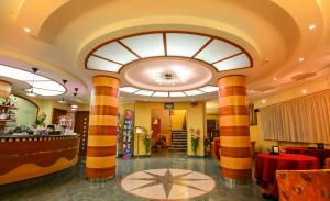 a restaurant with a large ceiling with columns in a room at Hotel Cavour in Cesenatico