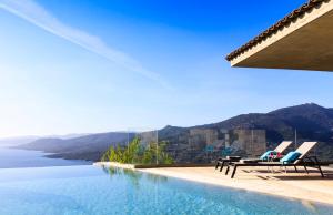 Una piscina con sillas y vista al agua. en Villa Supranu, en Viggianello