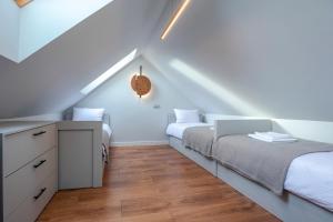 a attic bedroom with two beds and a dresser at Widok 3B/6 in Piechowice