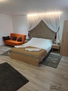 a bedroom with a large bed and a couch at Casa Mary Mar in Tîrgu Ocna