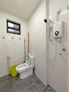 La salle de bains est pourvue d'une douche et de toilettes blanches. dans l'établissement VegeGarden Cozy Home @Ipoh Town Center, à Ipoh