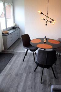 Zimmer mit einem Tisch und 2 Stühlen sowie einer Küche in der Unterkunft FeWo Friesenperle - Schillig in Horumersiel