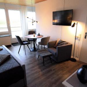 ein Wohnzimmer mit einem Sofa und einem Tisch in der Unterkunft FeWo Friesenperle - Schillig in Horumersiel