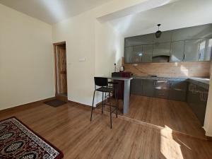 a kitchen with a counter and a table in a room at Alooma House in Vashisht