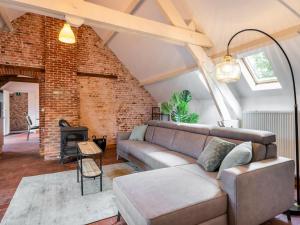 a living room with a couch and a brick wall at Nice apartment on UNESCO World Heritage Site Wortel Kolonie 