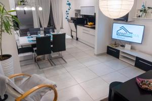 ein Wohnzimmer mit einem TV, einem Tisch und Stühlen in der Unterkunft Apartment MATEA in Kobarid