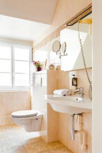 uma casa de banho com um WC e um lavatório em Logis Hotel Le Relais De La Poste Restaurant Le Fil du Temps em Thury-Harcourt