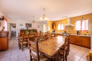 een keuken en eetkamer met een houten tafel en stoelen bij Maison des Vignes - 7 chambres in Saint-André +19 foto's
