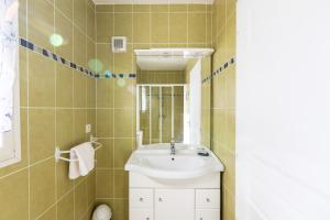 een badkamer met een wastafel en een spiegel bij Maison des Vignes - 7 chambres in Saint-André
