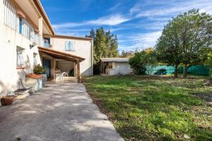 een oprit die leidt naar een huis met een tuin bij Maison des Vignes - 7 chambres in Saint-André