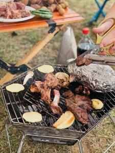 a grill with meat and other food on it at Camping Núi Thủng ở Cao Bằng in Cao Bằng