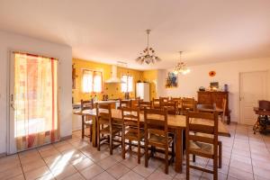 een eetkamer met een lange tafel en stoelen bij Maison des Vignes - 7 chambres in Saint-André