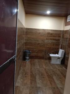 - une salle de bains avec toilettes dans une chambre dotée de murs en bois dans l'établissement SHREYASH RESORTS, 