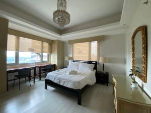a bedroom with a bed and a desk and a table at Avant at the Fort by Urban Realty in Manila
