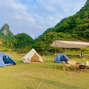 a group of tents and chairs in a field at Camping Núi Thủng ở Cao Bằng in Cao Bằng