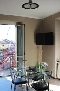 jadalnia ze szklanym stołem i krzesłami w obiekcie B&R Apartment w mieście Caselle Torinese