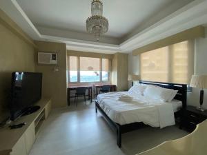 a bedroom with a bed and a flat screen tv at Avant at the Fort by Urban Realty in Manila