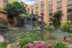 桂林的住宿－桂林喜來登飯店，一座带喷泉的建筑前的池塘