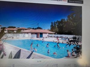 a picture of a swimming pool with people in it at Appart T3 Terrasse - Piscine - 3 étoiles in Saint-Cyprien