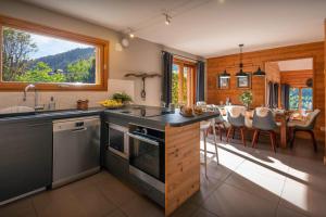 a kitchen with a sink and a table with chairs at Chalet Paravis - OVO Network in La Clusaz