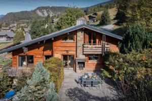 a large wooden house with a porch and a patio at Chalet Paravis - OVO Network in La Clusaz