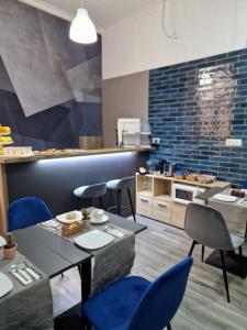 a restaurant with blue chairs and tables and a kitchen at B&B City Center in Naples