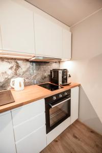 a kitchen with white cabinets and a stove top oven at Cabin Guesthouse in P&auml;rnu