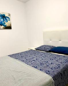 a bedroom with a bed with a blue comforter at Beautiful 1bd apartment in Los Cristianos in Adeje