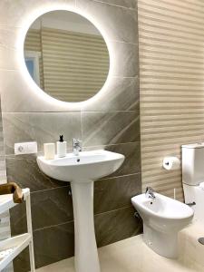 een badkamer met een wastafel, een spiegel en een toilet bij Beautiful 1bd apartment in Los Cristianos in Adeje