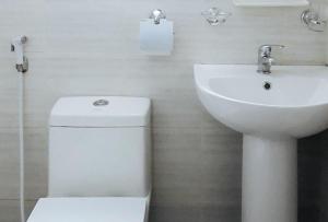 a white bathroom with a toilet and a sink at RedDoorz Bunakidz Lodge El Nido Palawan in El Nido